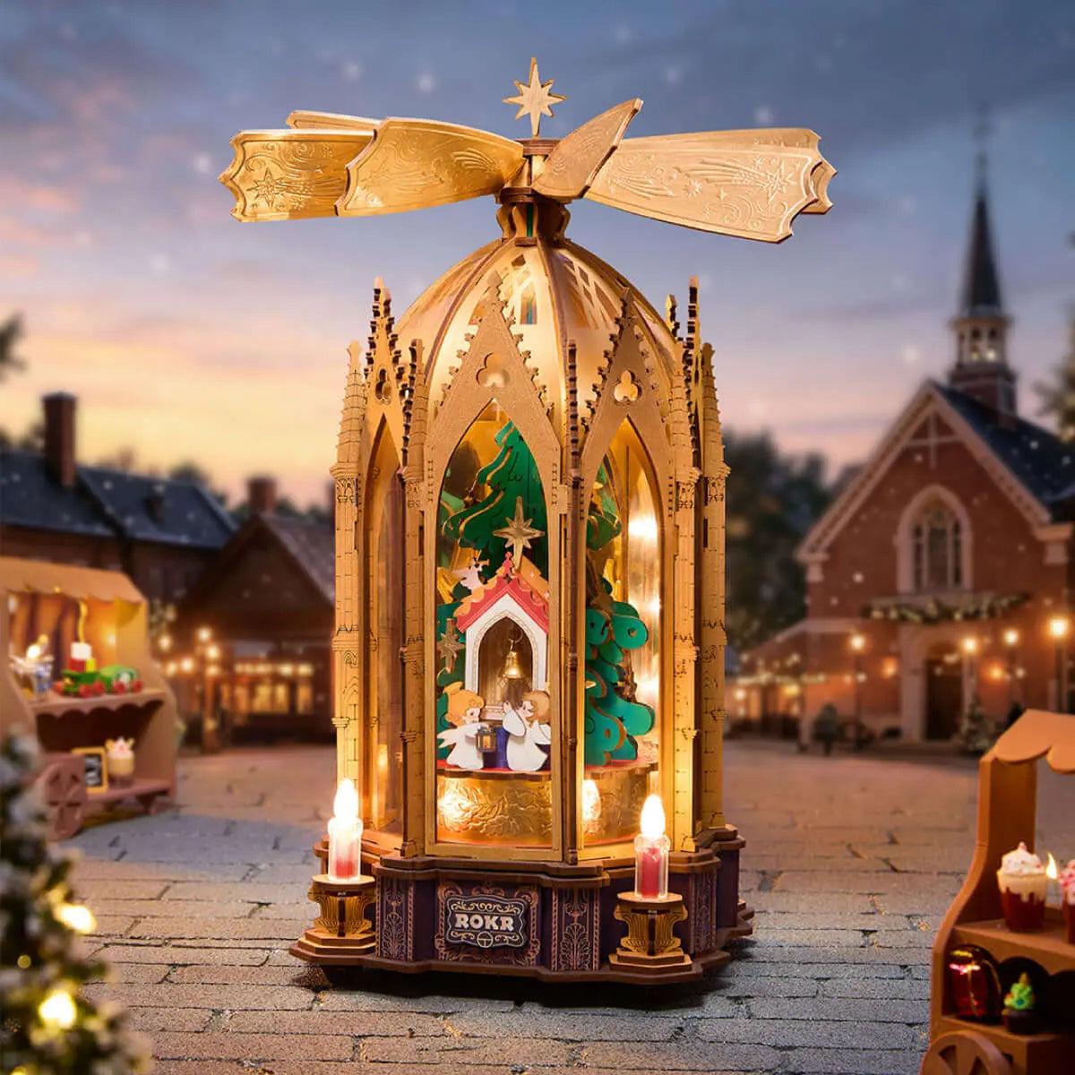 Illuminated ROKR AMB01 Christmas pyramid in a snowy Christmas market scene with a church in the background