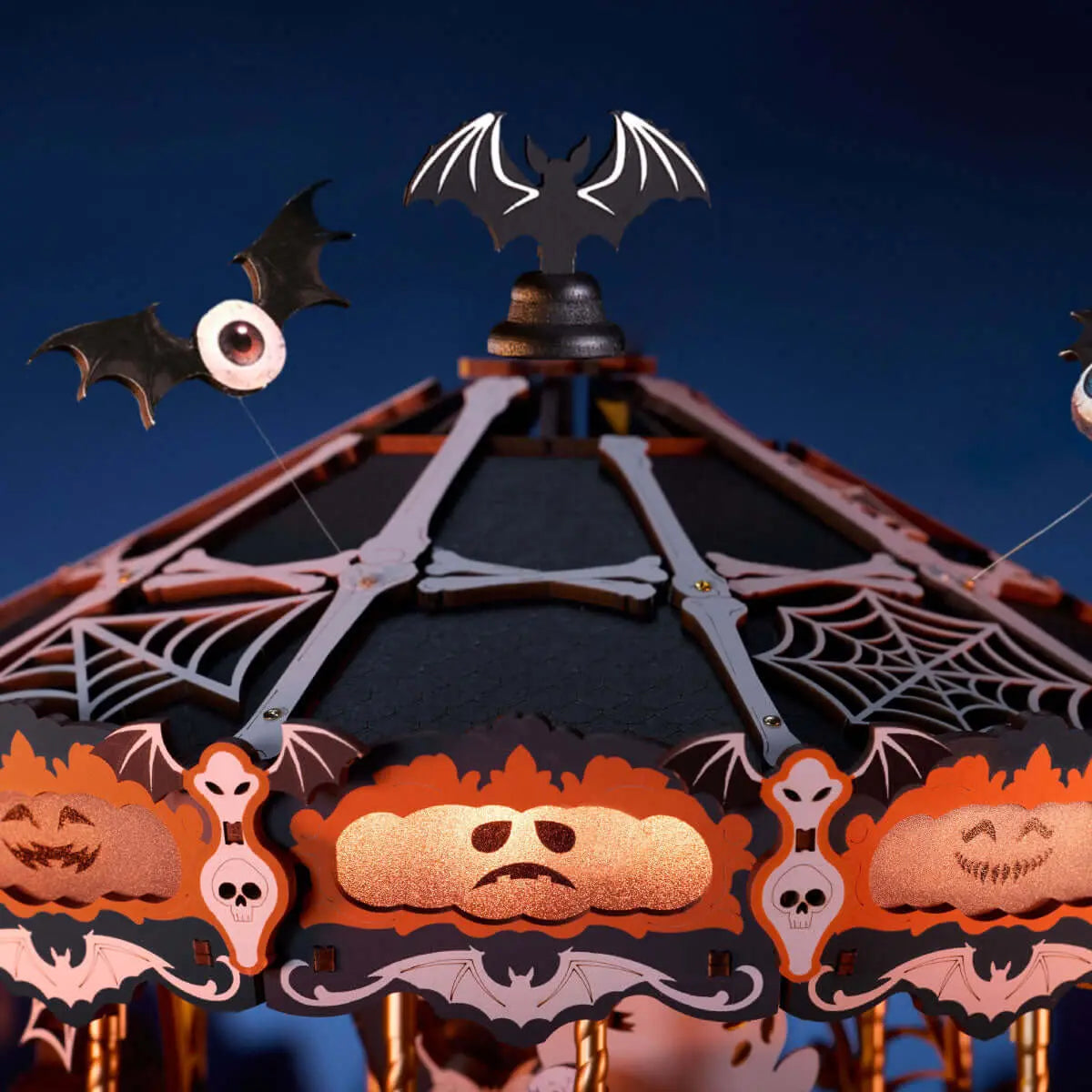 Close-up of the Phantom Waltz canopy with cobwebs, glowing pumpkin faces, skull trim and one-eyed bats.