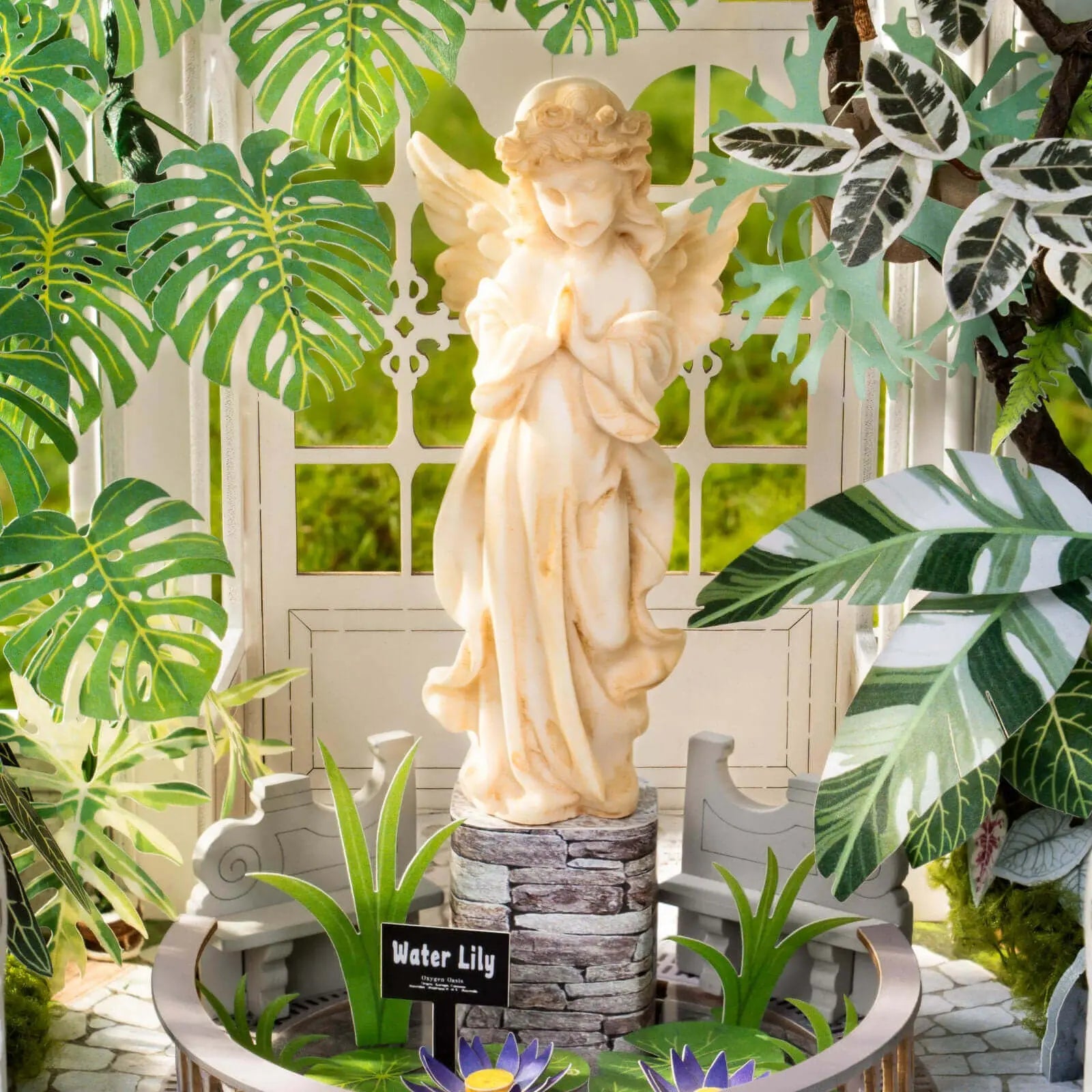 Angel statue, water lilies and garden benches inside the Rolife Oxygen Oasis greenhouse