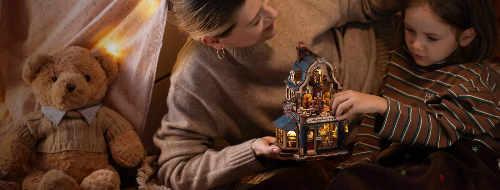 Adult and child exploring the illuminated ROKR Happyduke Toys EAM01 wooden 3D puzzle beside a teddy bear