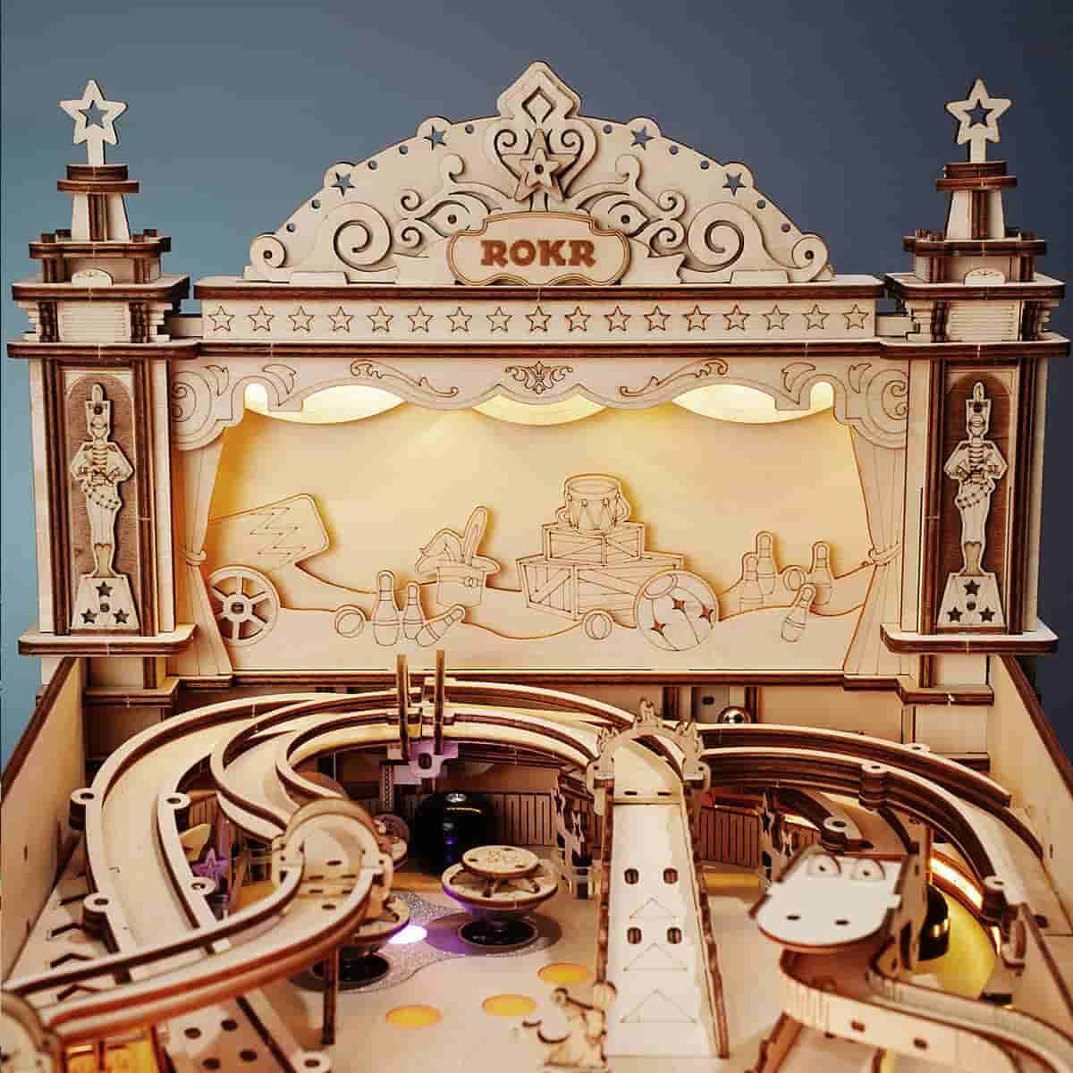 ROKR EG01 pinball machine close-up showing retro wooden backboard, upper tracks and illuminated playfield