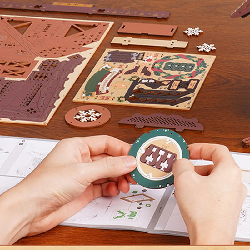 Hands holding a circular ROKR LCB01 wooden component beside pre-coloured puzzle sheets and assembly instructions.