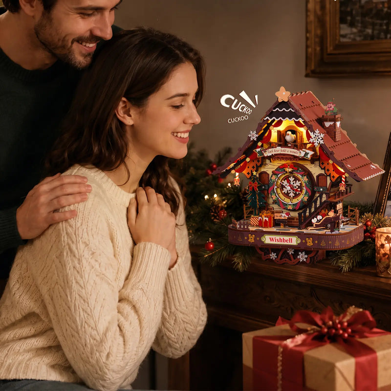 Couple admiring the illuminated ROKR LCB01 Christmas cuckoo clock beside festive greenery and a wrapped gift.