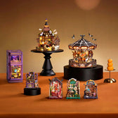 Glowing Phantom Waltz carousel on a tabletop beside an open book, pumpkin and spider decoration.