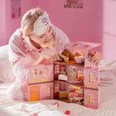 Builder arranging miniature furniture inside the open Fairy Rose Cottage