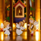 Three wooden angel figures with a lantern and trumpet in front of the glowing ROKR AMB01 Christmas pyramid
