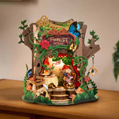 Illuminated Rolife Forest Tea Party AMT03 music box displayed on a wooden cabinet, with a miniature tea table and woodland decorations.