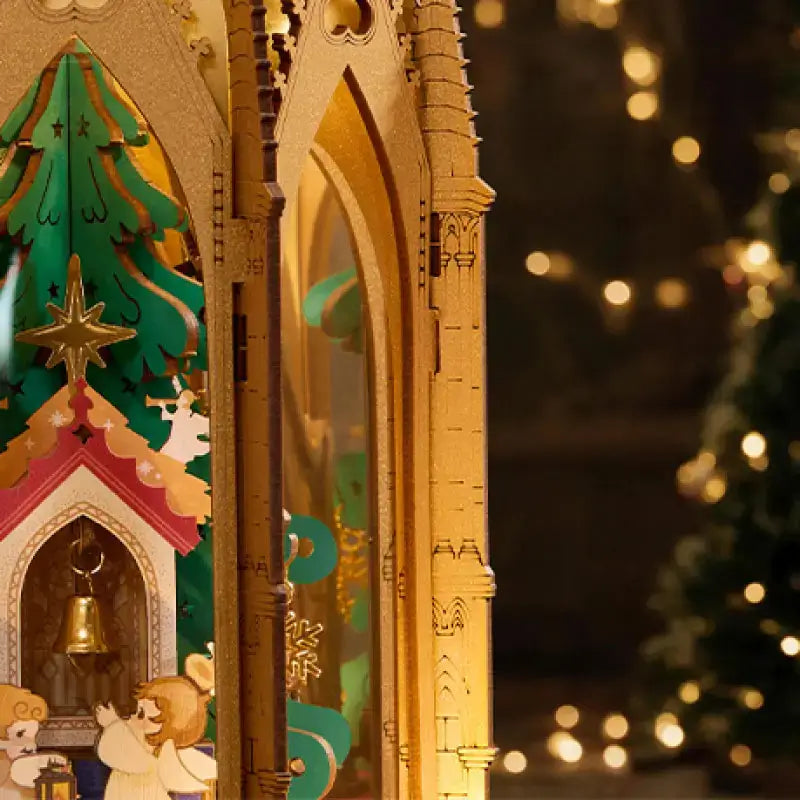 Golden wooden side supports beside the miniature Christmas tree, bell and angels in the ROKR AMB01 pyramid.