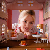 Child looking through the furnished rooms of the open Fairy Rose Cottage