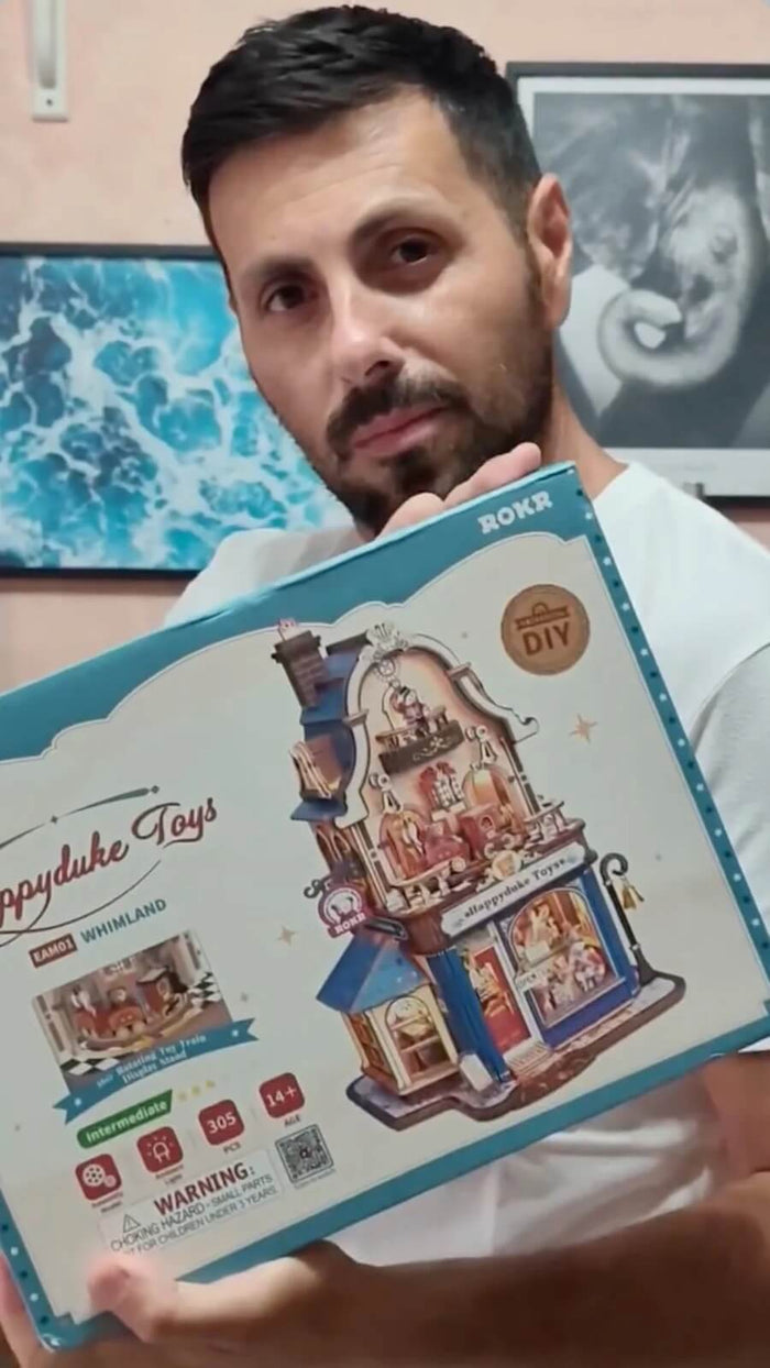 Builder holding the ROKR Happyduke Toys EAM01 wooden 3D puzzle kit