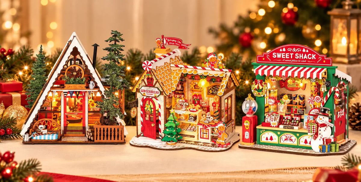 A-frame cabin, gingerbread bakery and Sweet Shack candy stand miniatures displayed with Christmas lights and decorations.