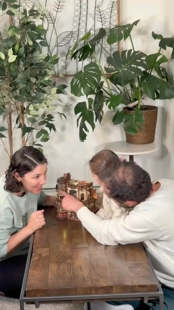 Family exploring the completed Dream Coffee Factory wooden puzzle together