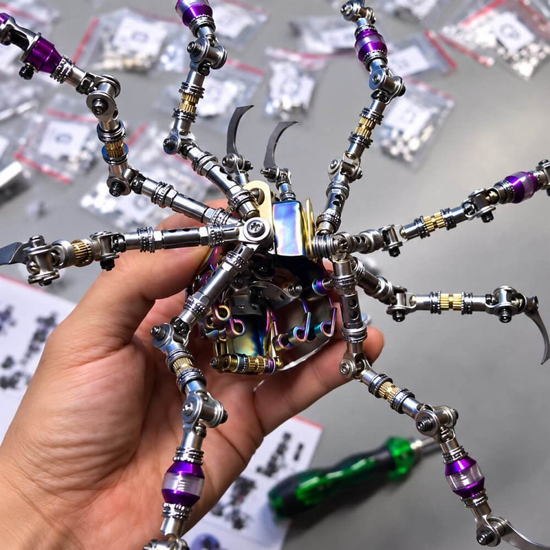 A hand holding the Plasma Ball Spider’s metal body and articulated legs during assembly.