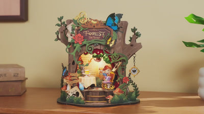 A hand pulling the pocket-watch pendant to switch the Rolife Forest Tea Party music box on and off