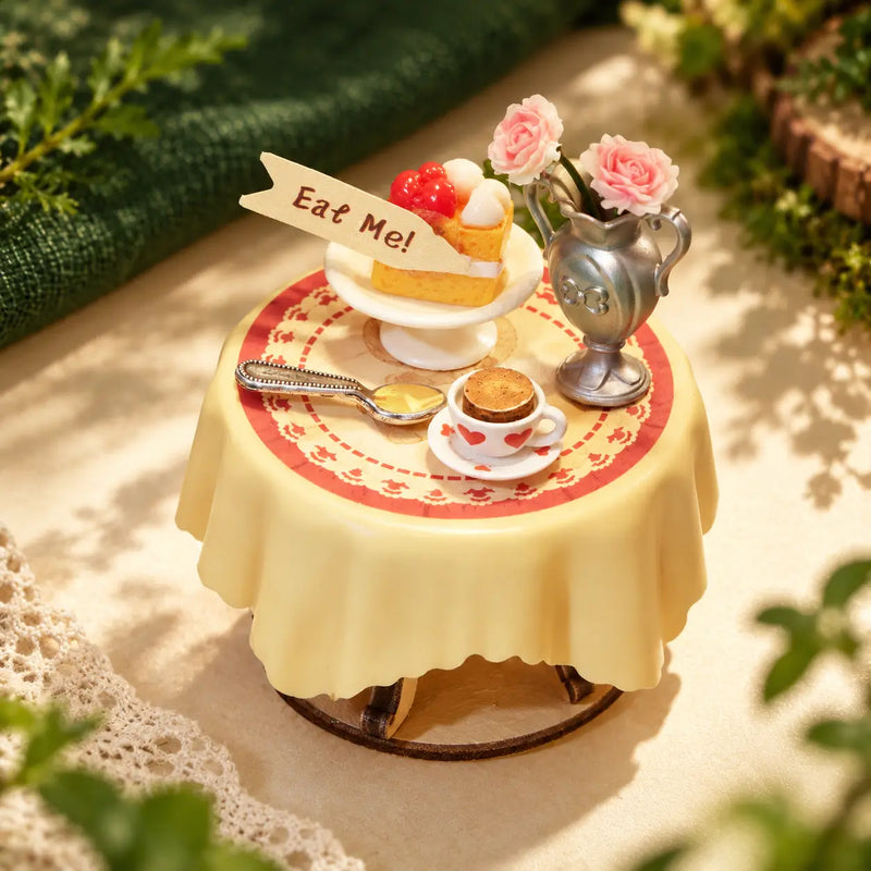 Miniature tea table from the Rolife Forest Tea Party kit with a cake, heart-patterned cup and roses