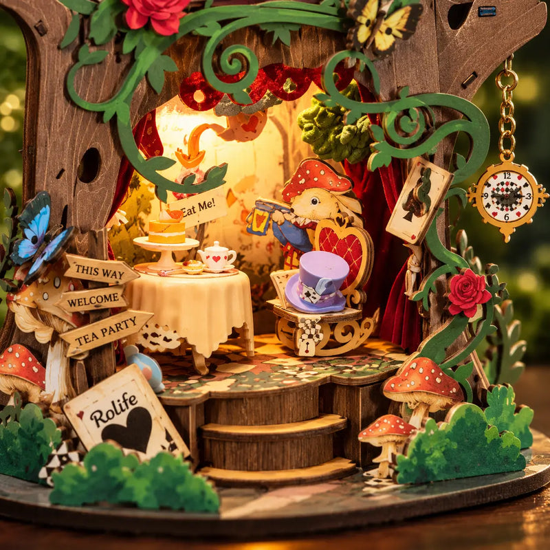 Close-up of the Rolife Forest Tea Party music box with a lit storybook, tea table and hanging pocket watch