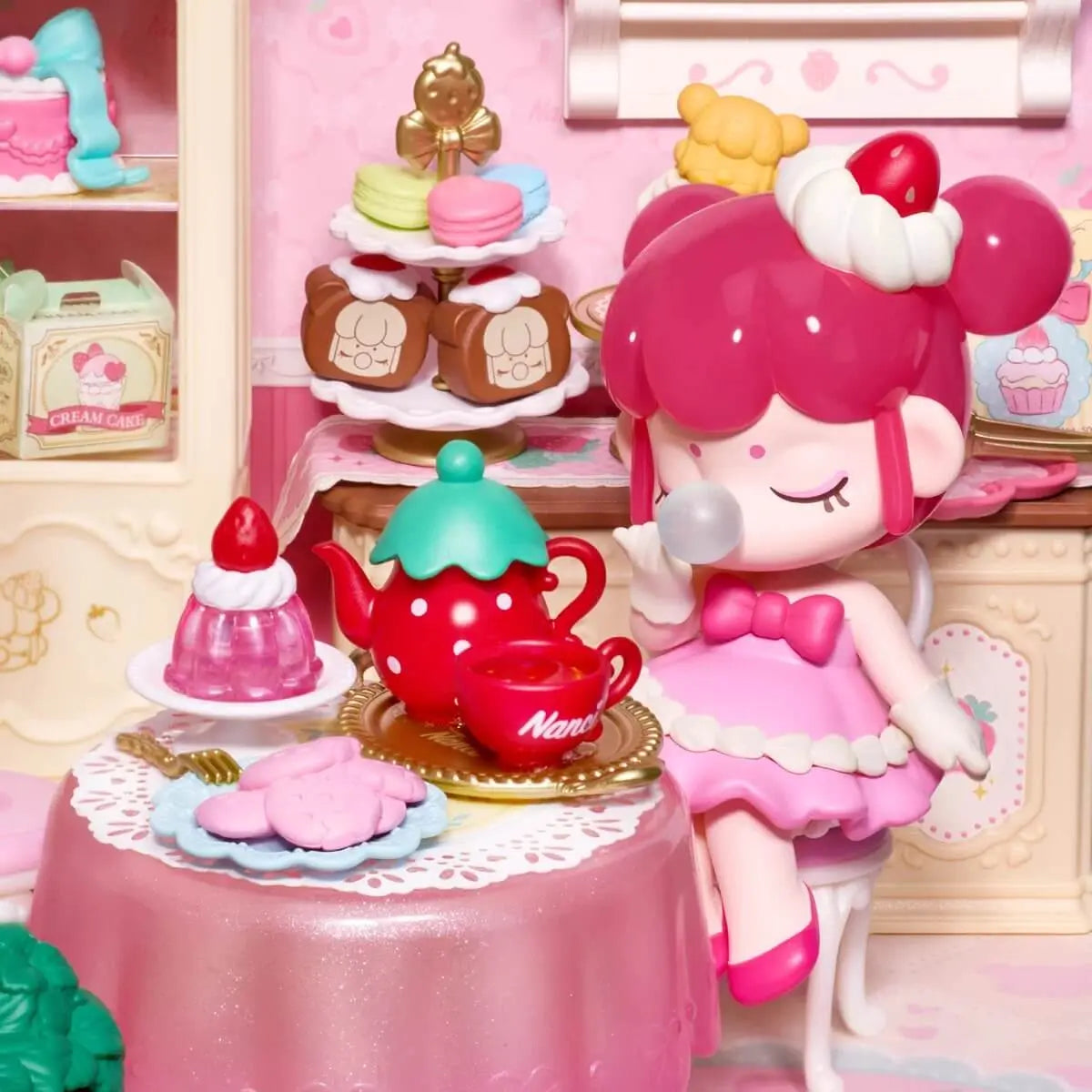 Close-up of the included Nanci figure with strawberry teapot, cup and miniature desserts