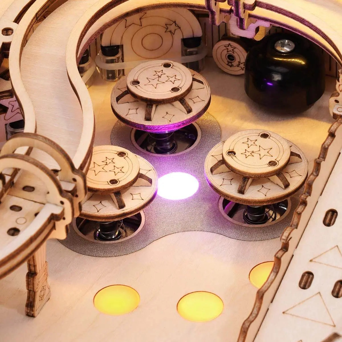 Close-up of illuminated rebound bumpers inside the wooden pinball machine upper playfield